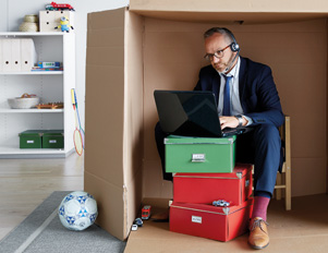 Mitarbeiter im Homeoffice, versteckt im Karton