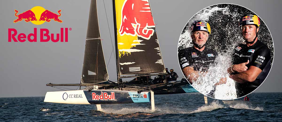 Logo: Red Bull; Abbildung: Roman Hagara und Hans-Peter Steinacher sowie ein Segelboot