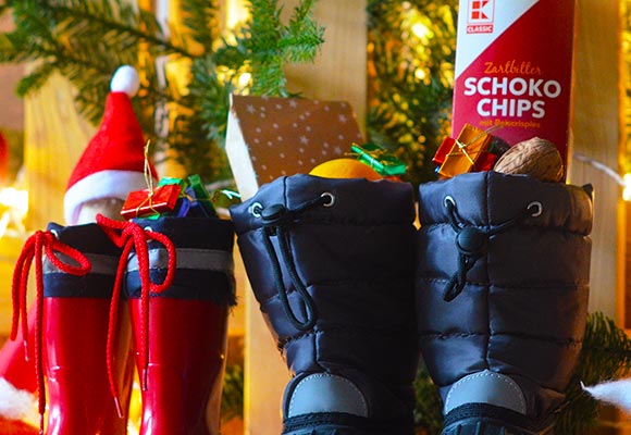 Zwei Paar Stiefel mit Süßigkeiten und Obst