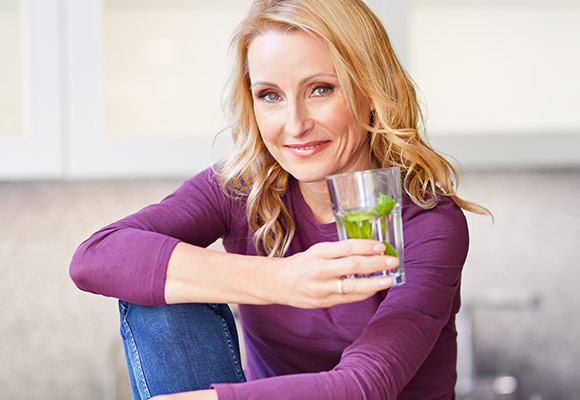 Abbildung: Ernährungsexpertin Dr. Alexa Iwan mit einem Wasserglas