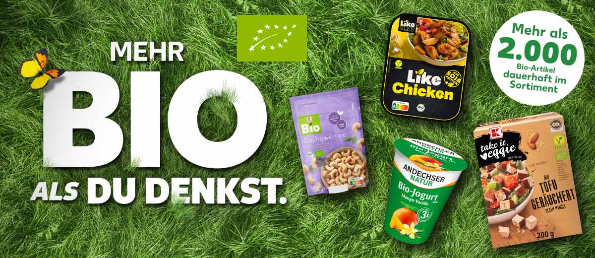 Schriftzug: MEHR BIO ALS DU DENKST.; Siegel: Bio; Störer: Mehr als 2.000 Bio-Artikel dauerhaft im Sortiment; Produktabbildungen: K-BIO Cashewkerne, LIKE MEAT Like Chicken, ANDECHSER NATUR Bioland-Joghurt, K-TAKE IT VEGGIE Bio-Tofu