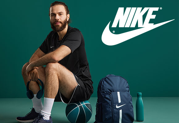Logo: NIKE; Abbildung: Ein Mann sitzt auf einem Basketball und trägt verschiedene Artikel von Nike. Neben ihm befindet sich ein Nike Rucksack und eine Trinkflasche