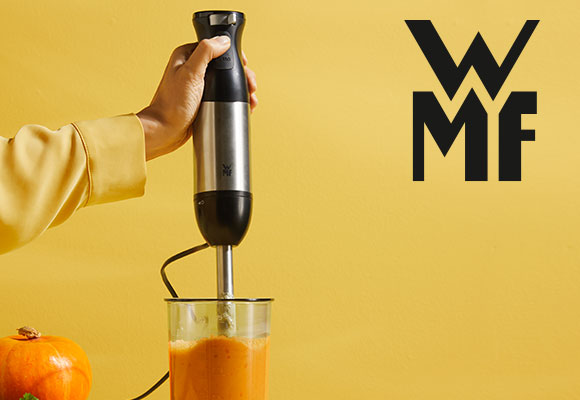 Logo: WMF; Abbildung: Eine Person püriert einen Kürbis mit einem Stabmixer