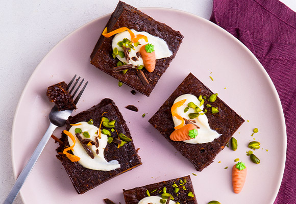 Abbildung: Brownies mit Topping und einer Gabel auf einem rosafarbenen Teller