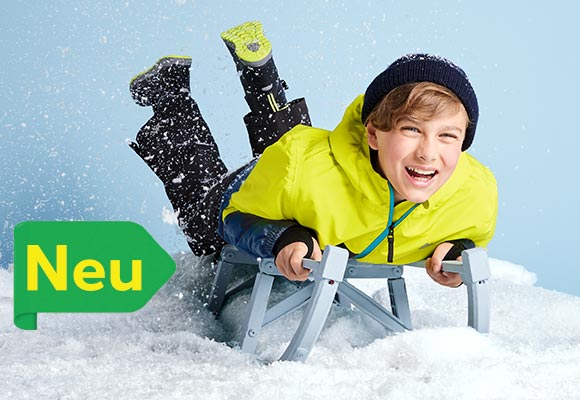Abbildung: Ein Junge in Skibekleidung liegt auf einem Schlitten; Logo: Neu