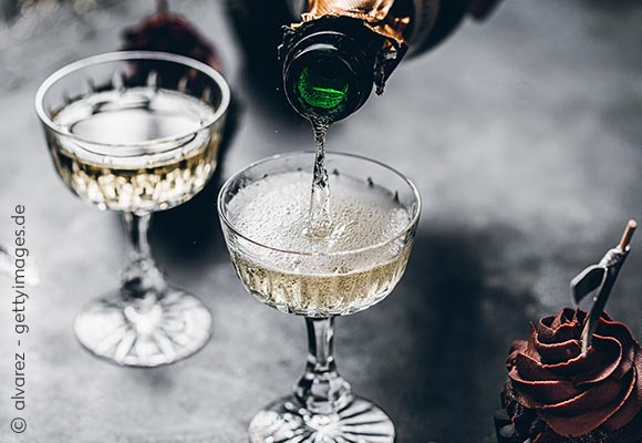 Abbildung: Zwei Champagnergläser auf einem dunklen Hintergrund; © alvarez - gettyimages.de