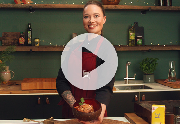 Abbildung: Köchin Verena Leister hält Kloß-Fries mit Preiselbeer-Majo in der Hand; Abbildung: Play-Button