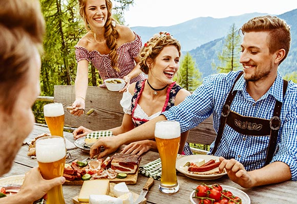 Abbildung: Mehrere Personen beim Essen auf einer Alpenhütte