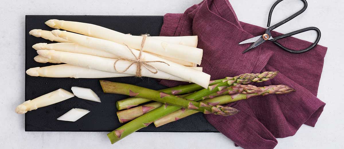 Abbildung: Weißer und grüner Spargel auf einem Brett