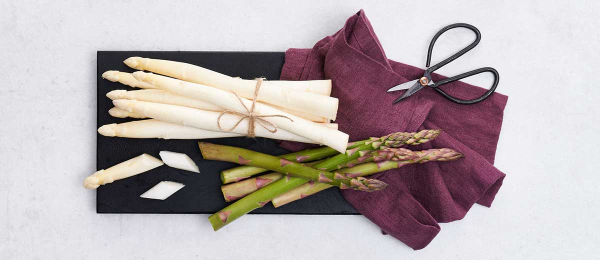 Abbildung: Grüner und weißer Spargel auf einem Tablett