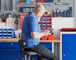 Mann in der Werkstatt mit Werkzeug in der Hand